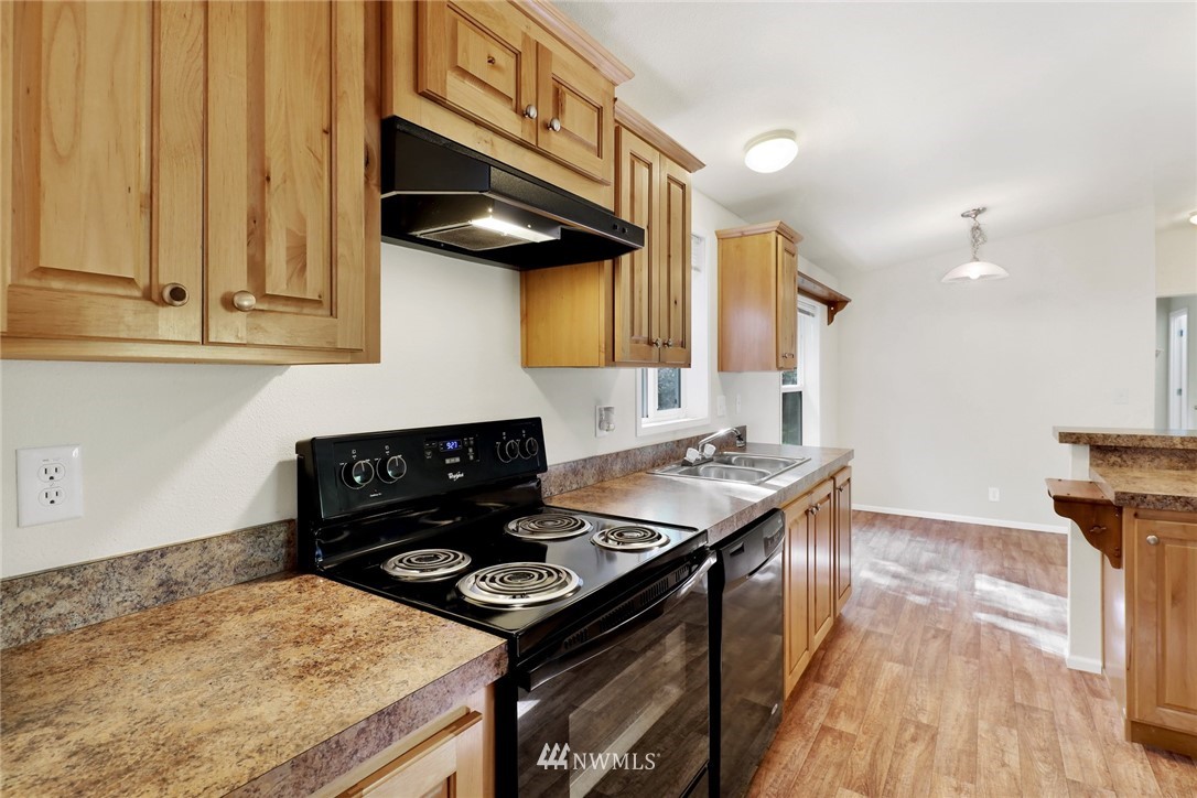 6752 Goodwin Road Everson, WA 98247 - Photo 11 of 28 a kitchen with a stove and a wooden floor
