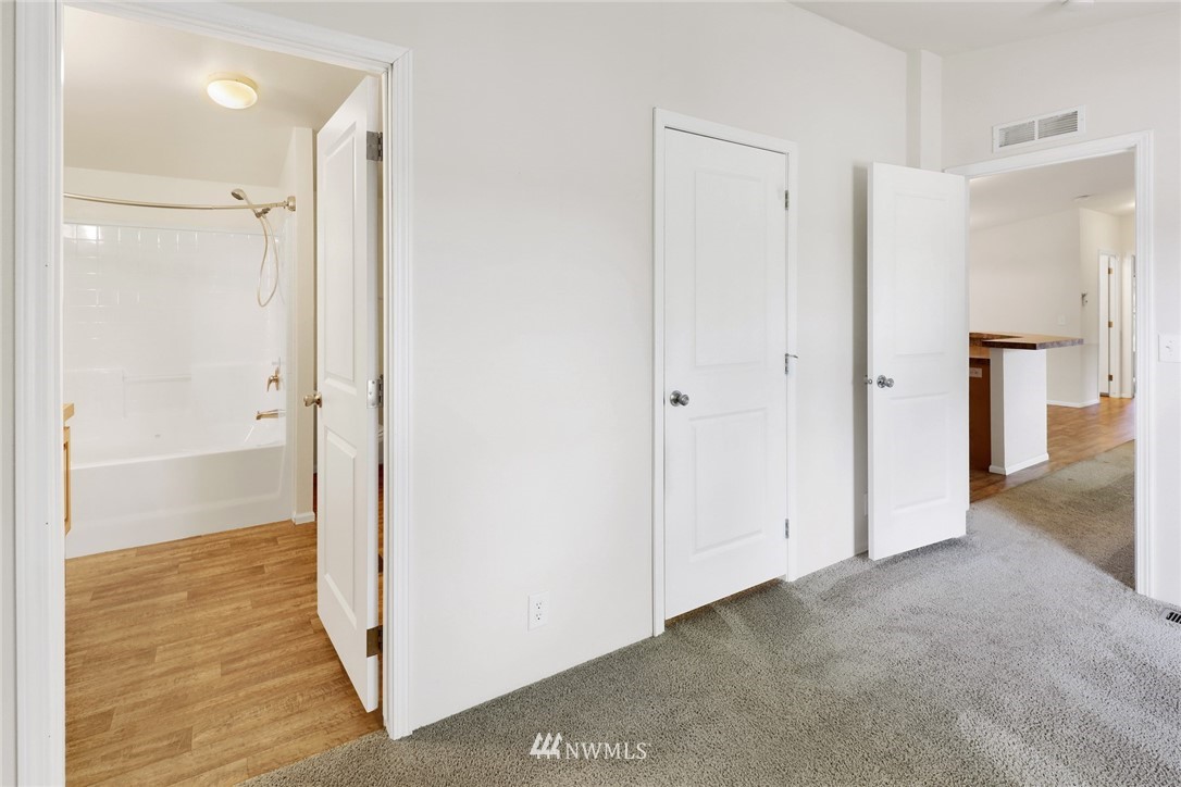 6752 Goodwin Road Everson, WA 98247 - Photo 17 of 28 a view of an empty room with wooden floor and a bathroom