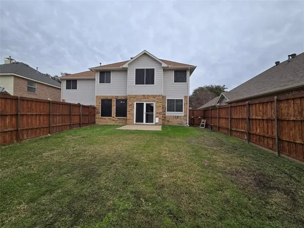 a view of a house with a yard and sitting area