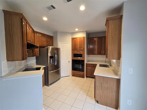 a kitchen with a refrigerator sink and cabinets