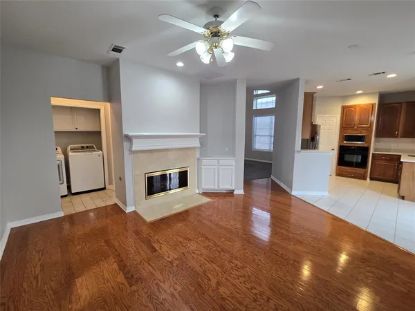 a view of a livingroom with a fireplace a chandelier and wooden floor
