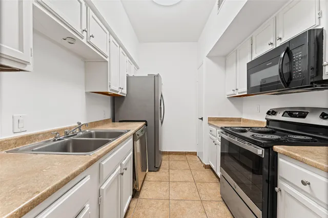 a kitchen with stainless steel appliances granite countertop a sink stove and microwave
