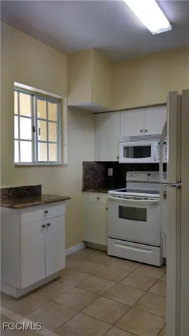 a kitchen with granite countertop a stove sink and cabinets
