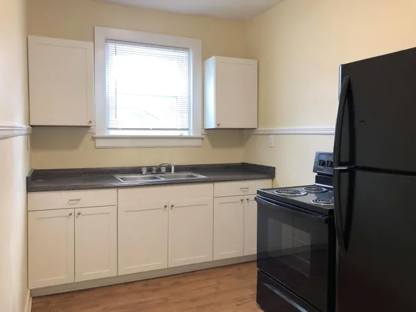 a kitchen with metallic refrigerator and white cabinets