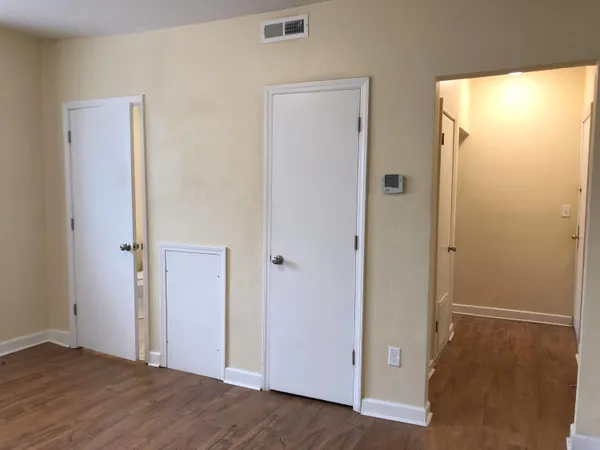 a view of an empty room with wooden floor
