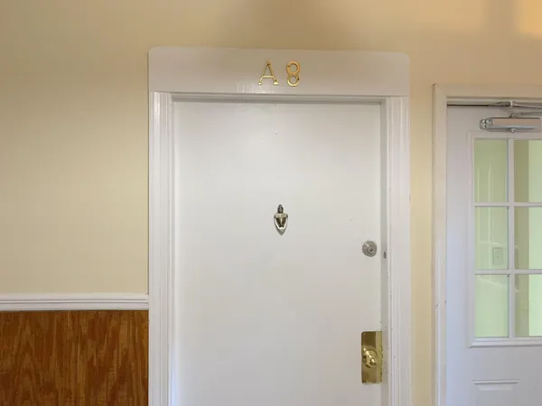 a kitchen with white cabinets and a refrigerator