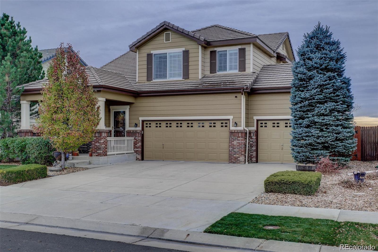 a front view of a house with a garden and garage