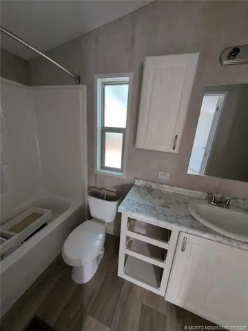 a bathroom with a granite countertop toilet sink and mirror