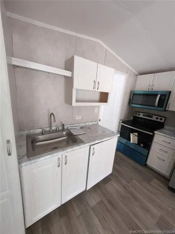 a kitchen with granite countertop a sink and a stove top oven