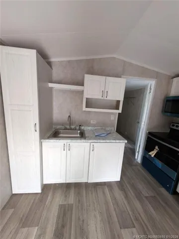 a kitchen with kitchen island wooden floors and stainless steel appliances