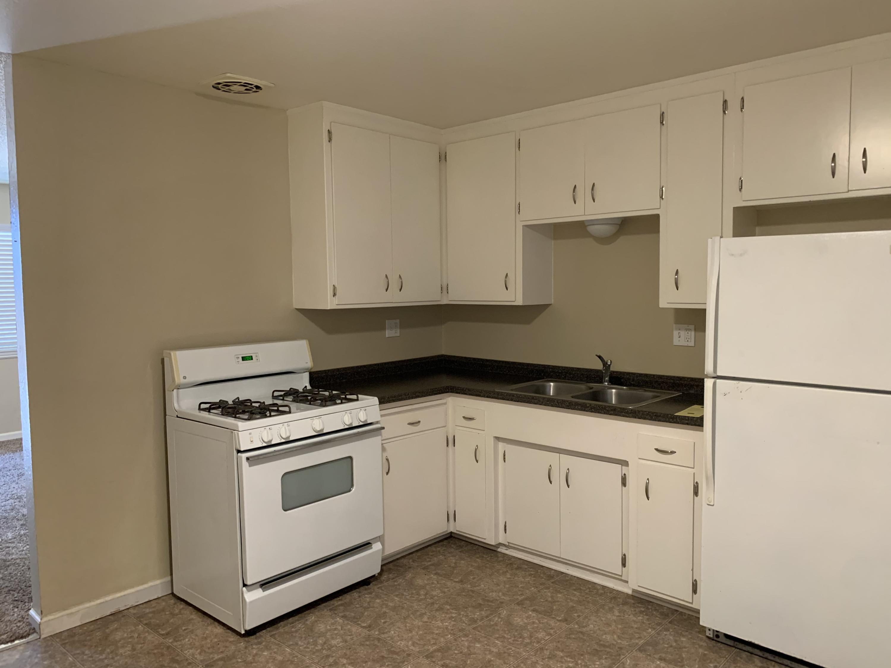 3242 Lawrence Road Redding, CA 96002 - Photo 3 of 17 a kitchen with granite countertop white cabinets and white appliances