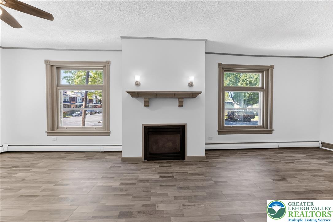 1128 Maple Street Bethlehem, PA 18018 - Photo 32 of 34 A refined fireplace with a classic mantel anchors this light-filled room, featuring handsome wood flooring and large windows.