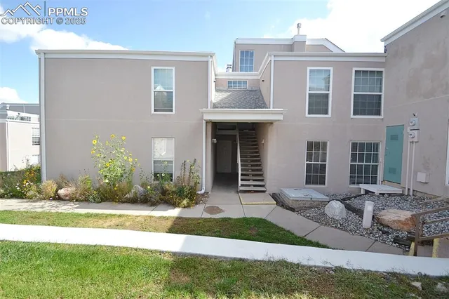a front view of a house with garden and plants