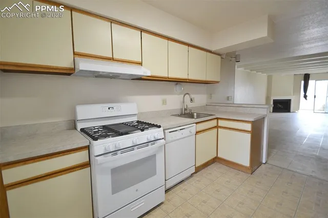 a kitchen with granite countertop white cabinets and white appliances