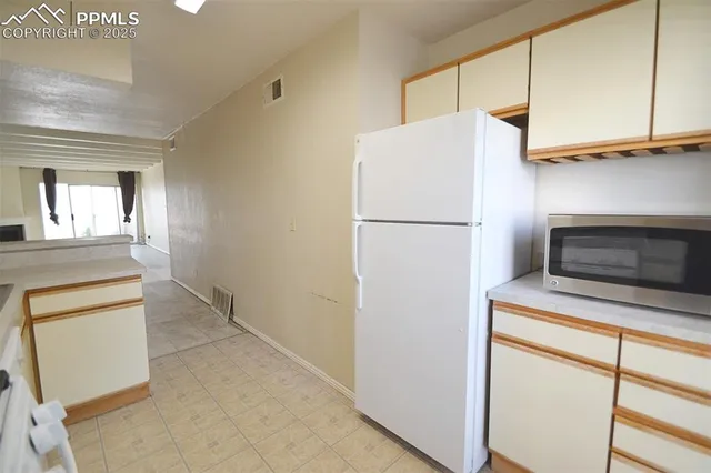 a white refrigerator freezer and a stove sitting inside of a kitchen