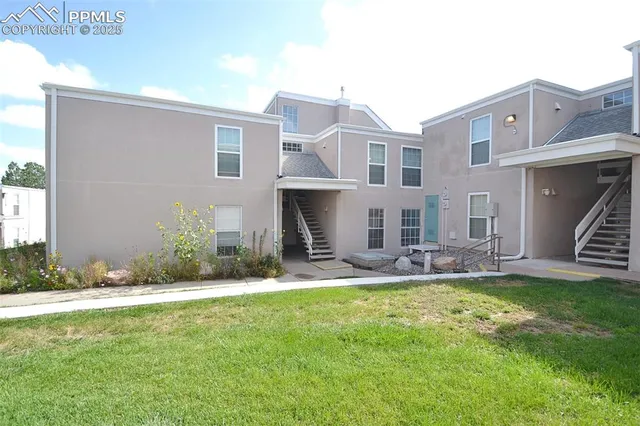 a view of a house with a yard and sitting area