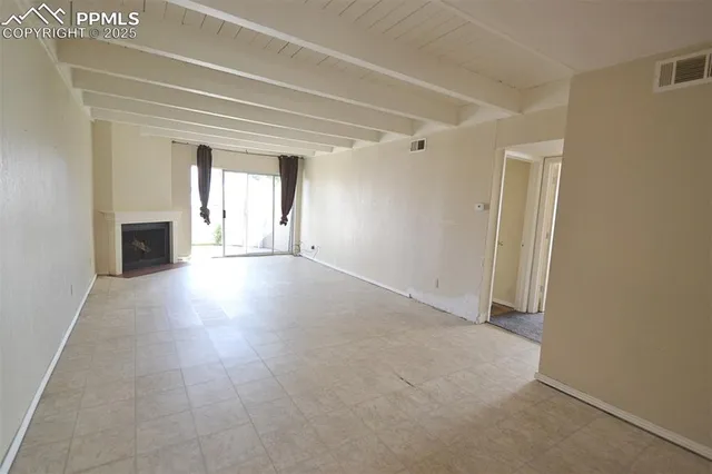 an empty room with windows and a fireplace