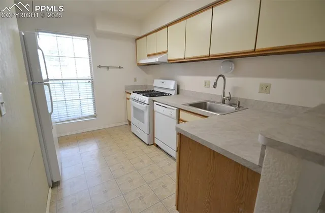 a kitchen with stainless steel appliances granite countertop a sink and a white cabinets
