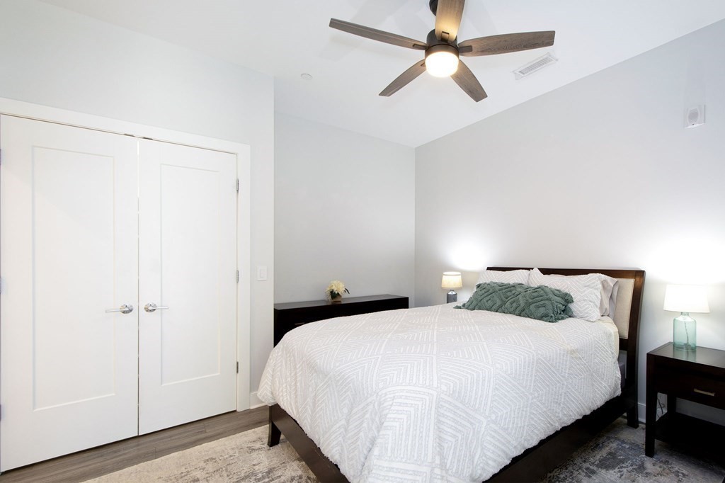10 Shipyard Drive, Unit 102 Hingham, MA 02043 - Photo 12 of 31 a bedroom with a bed and a ceiling fan