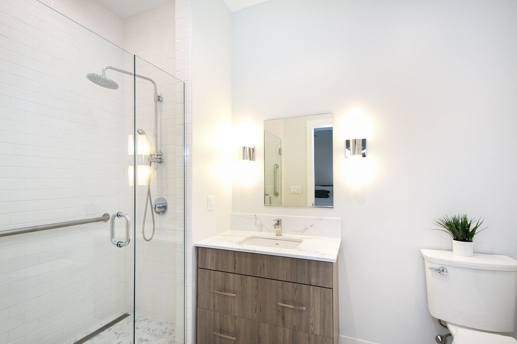 10 Shipyard Drive, Unit 102 Hingham, MA 02043 - Photo 16 of 31 a bathroom with a sink a toilet and shower