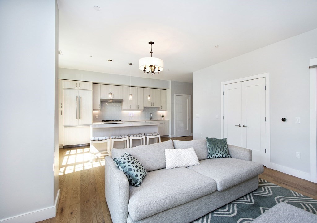 10 Shipyard Drive, Unit 102 Hingham, MA 02043 - Photo 2 of 31 a living room with furniture and a chandelier