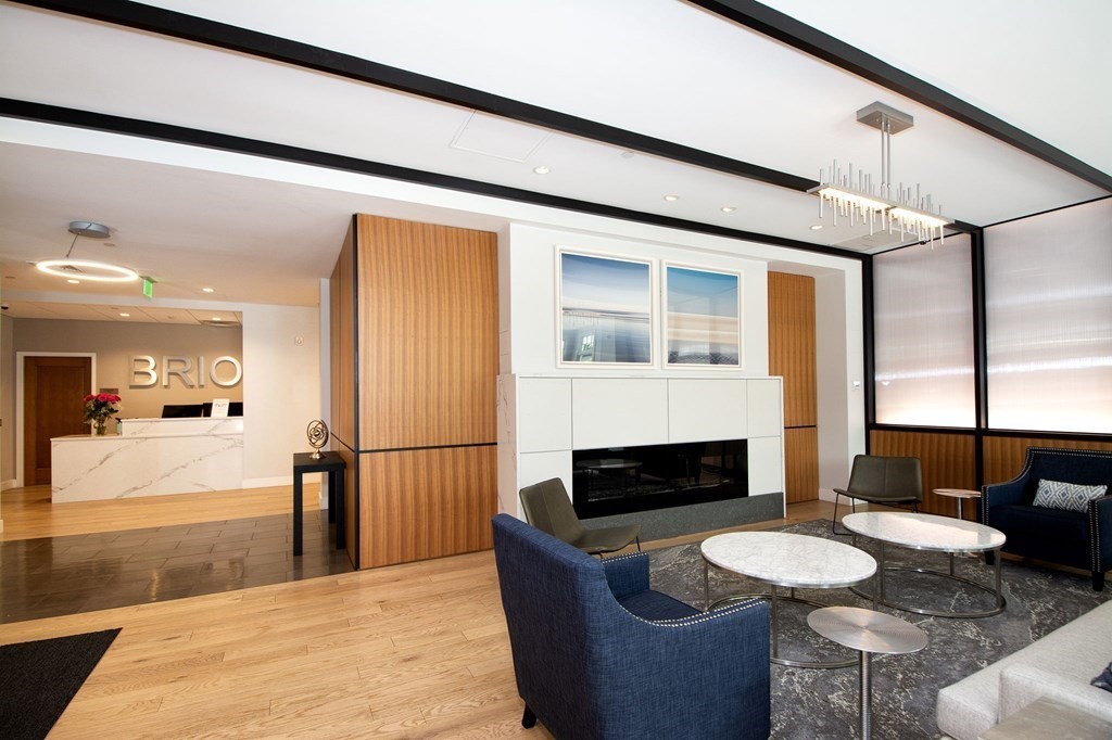 10 Shipyard Drive, Unit 102 Hingham, MA 02043 - Photo 25 of 31 a living room with furniture a fireplace and a floor to ceiling window