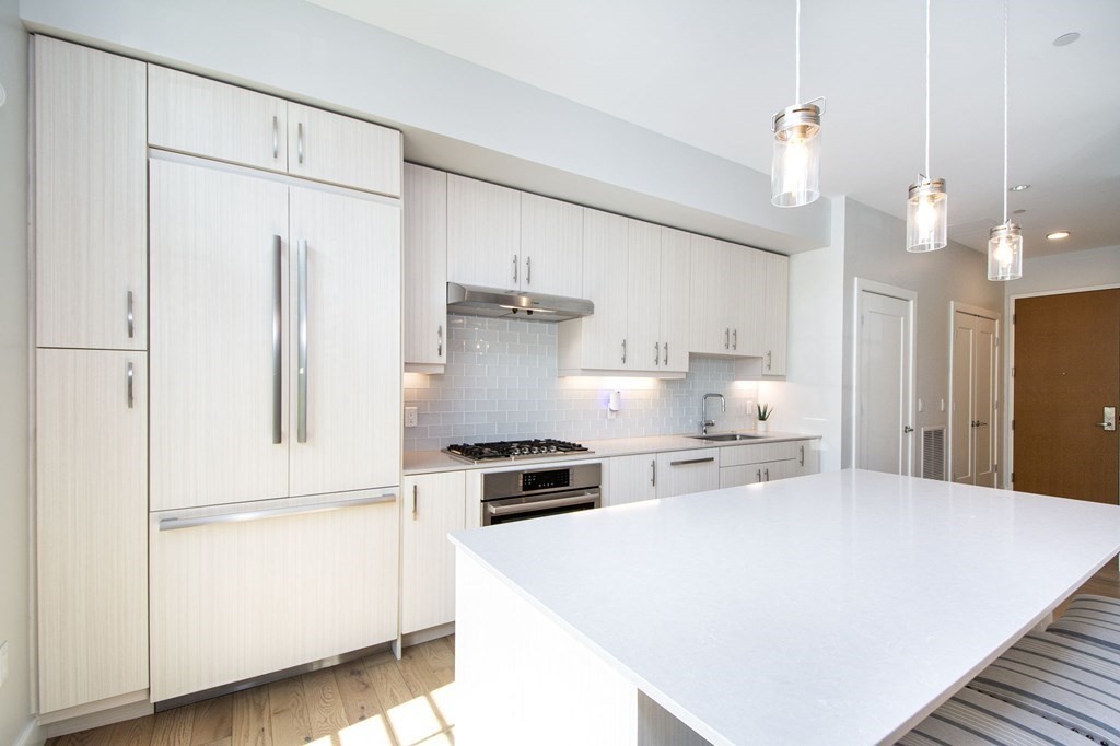 10 Shipyard Drive, Unit 102 Hingham, MA 02043 - Photo 4 of 31 a kitchen with a refrigerator a stove and white cabinets