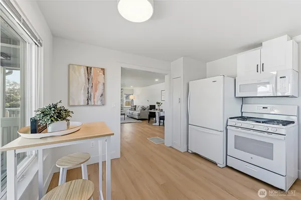a kitchen with furniture a refrigerator and wooden floor