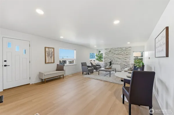 a living room with furniture a window and wooden floor