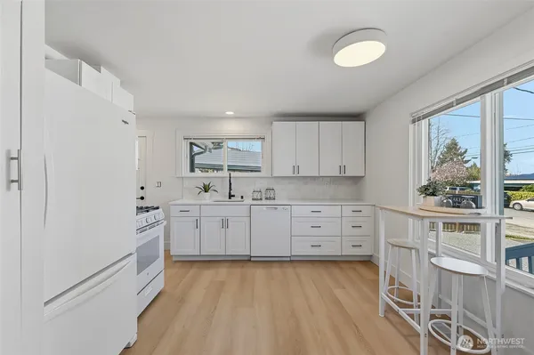 a kitchen with white cabinets and white appliances