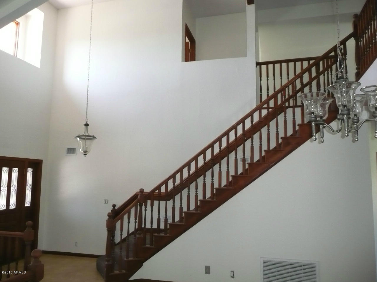 4128 West Elliot Road Laveen, AZ 85339 - Photo 35 of 114 a view of staircase with railing pendant lights and windows