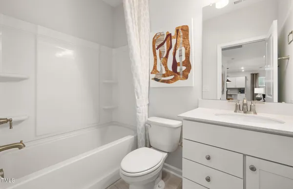 a bathroom with a toilet sink vanity tub and shower