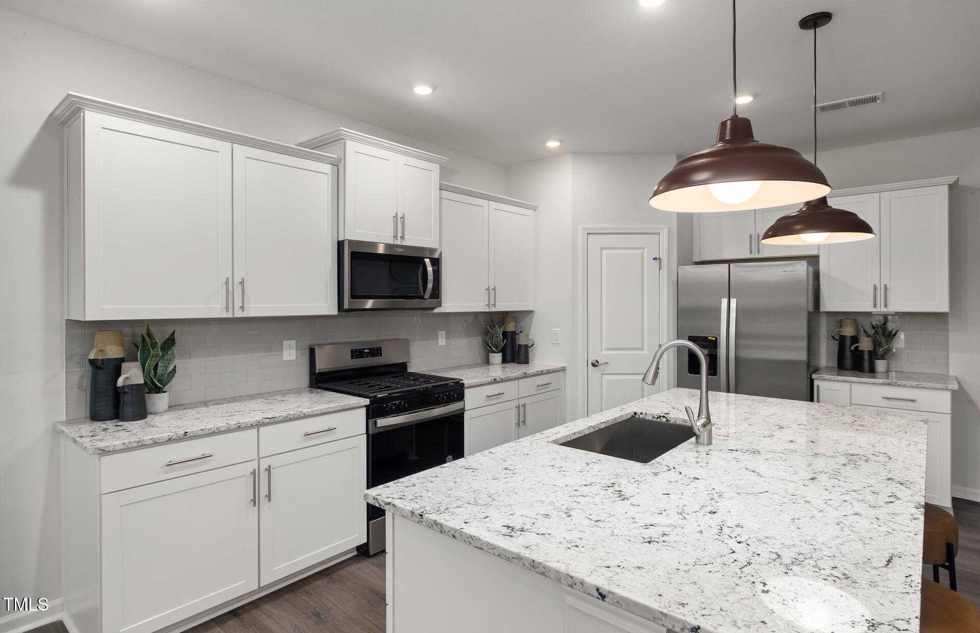 457 Grange Farm Place Raleigh, NC 27603 - Photo 3 of 30 a kitchen with a sink a stove and refrigerator