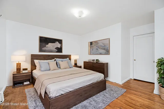 a bedroom with a bed and a painting on the wall