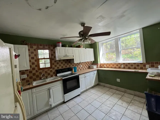 a kitchen with stainless steel appliances kitchen island granite countertop a sink and a stove
