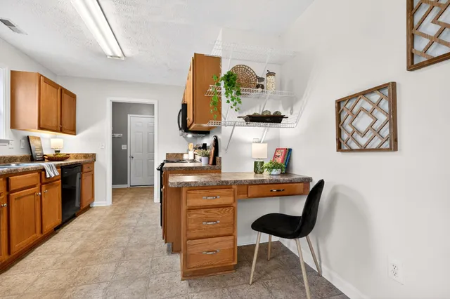 a kitchen with stainless steel appliances granite countertop a refrigerator a stove and a sink with wooden floor