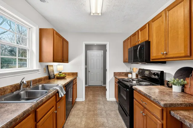 a kitchen with stainless steel appliances granite countertop a sink counter space and cabinets