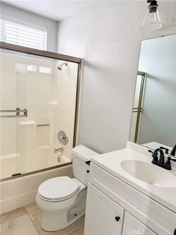 a bathroom with a sink a toilet a mirror and shower