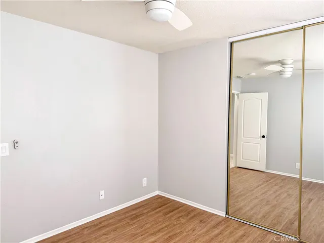 an empty room with wooden floor and mirror
