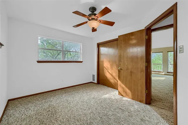 an empty room with a ceiling fan and wooden floor
