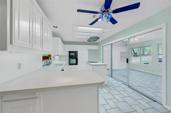 a white kitchen with cabinets and wooden floor