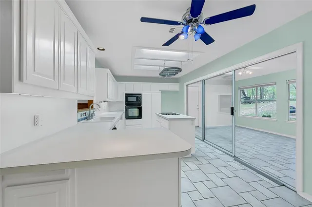 a white kitchen with cabinets and wooden floor