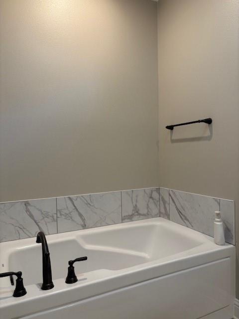 6896 Bethany Reed Circle Blanchard, LA 71107 - Photo 6 of 9 Soaking tub featuring matte black fixtures, an integral seat, and a tiled surround with a marble-look finish