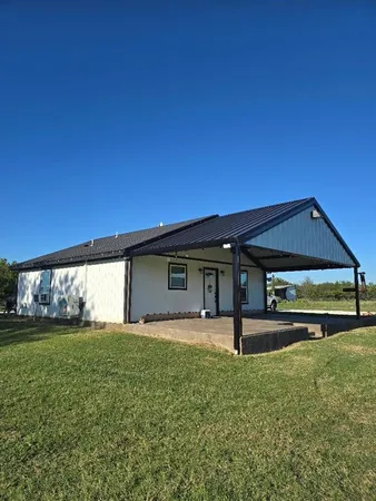 a view of a house with a yard and sitting area