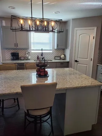 a kitchen with stainless steel appliances a table chairs in it and wooden floor