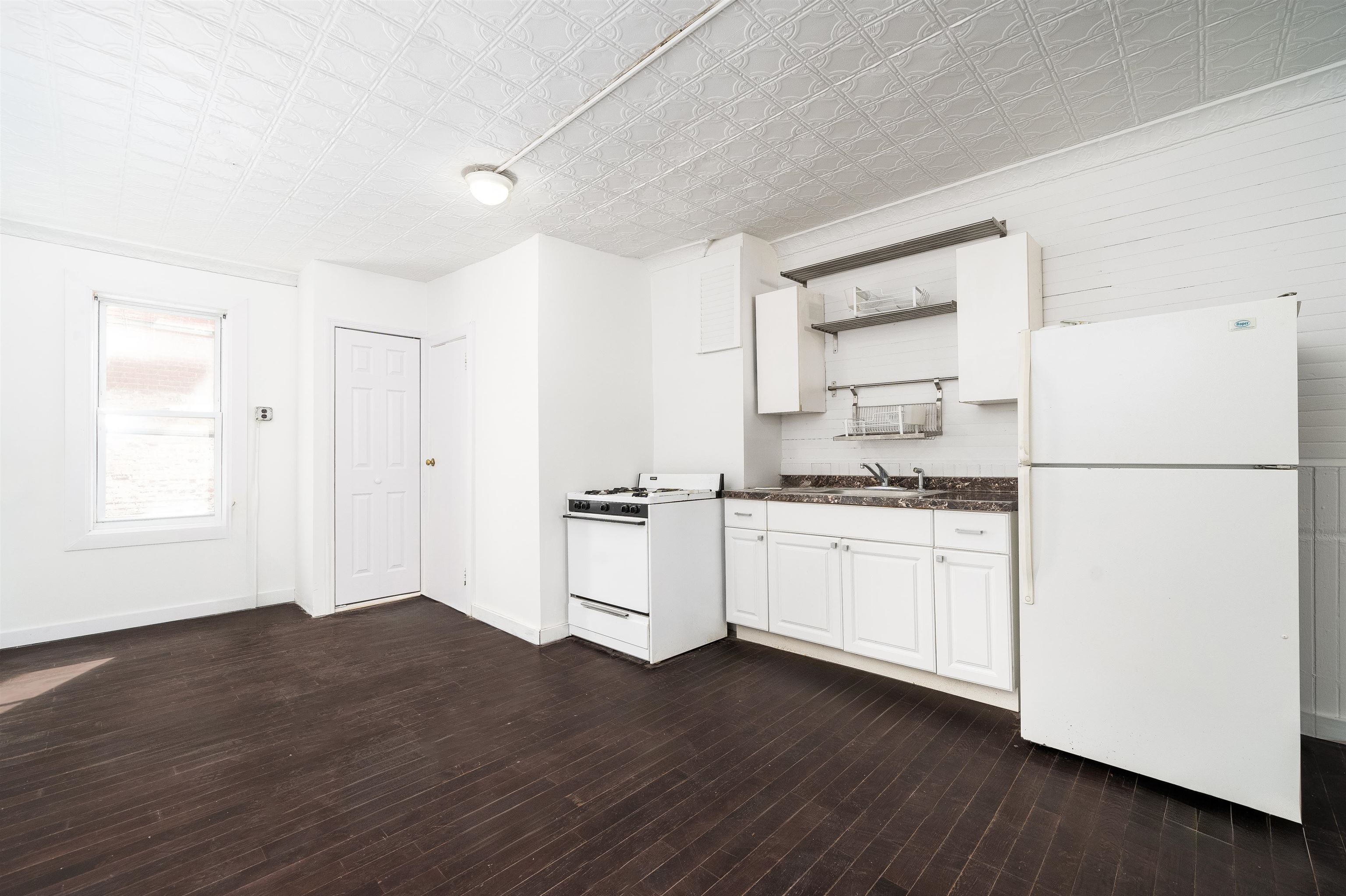 74 Colgate Street, Unit 1 Jersey City, NJ 07302 - Photo 6 of 12 a kitchen with a refrigerator and white cabinets