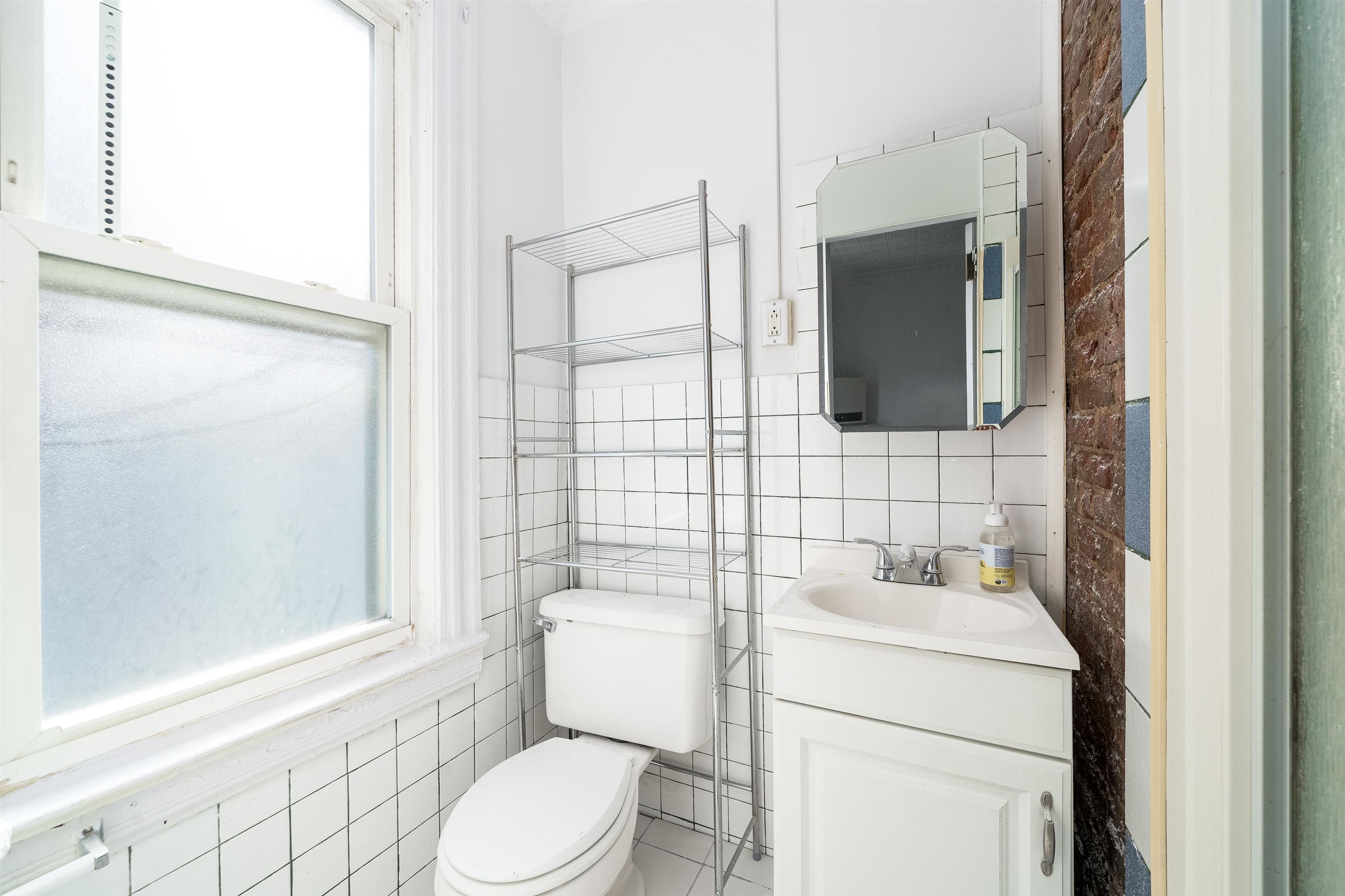74 Colgate Street, Unit 1 Jersey City, NJ 07302 - Photo 9 of 12 a bathroom with a toilet sink and mirror