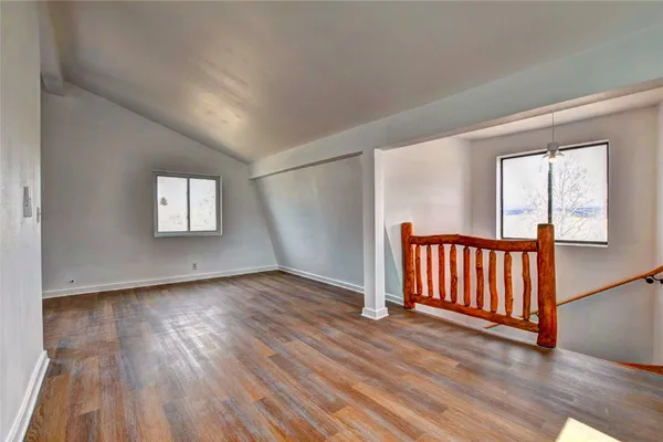 a view of empty room with wooden floor