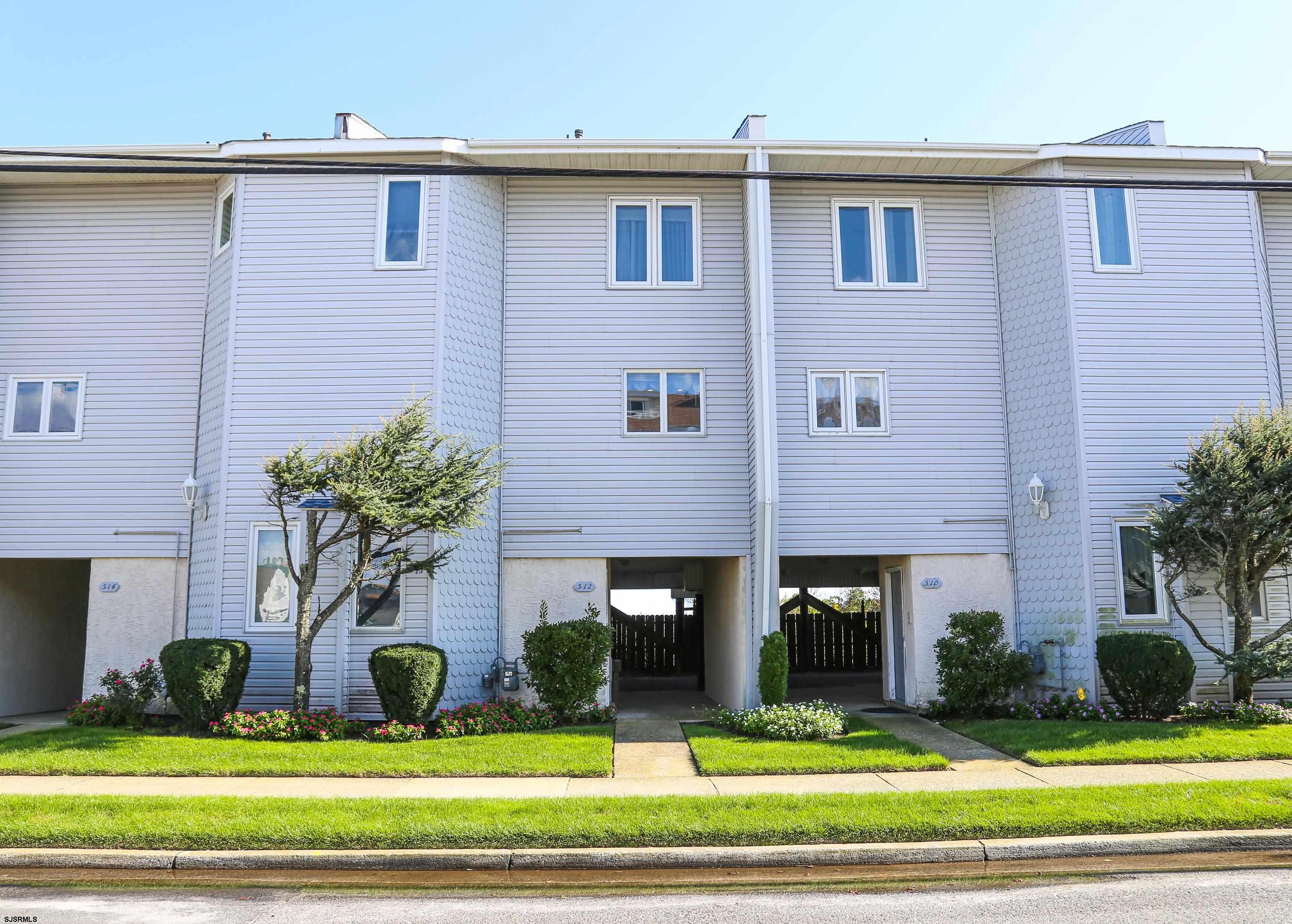 512 East Brigantine Avenue, Unit 512 Brigantine, NJ 08203 - Photo 11 of 46 a front view of a house with garden and garage
