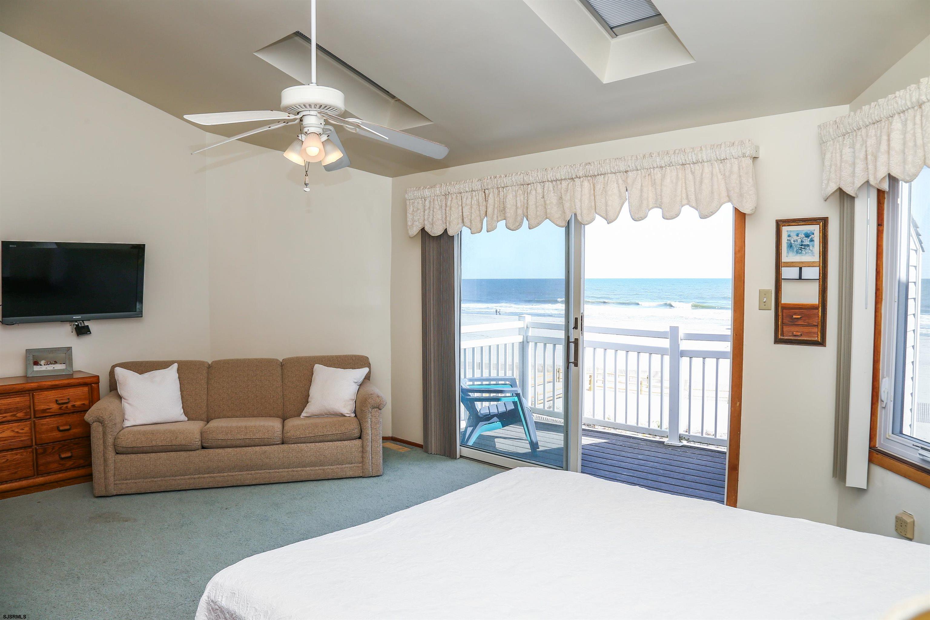 512 East Brigantine Avenue, Unit 512 Brigantine, NJ 08203 - Photo 16 of 46 a bedroom with a bed couch and a flat tv screen